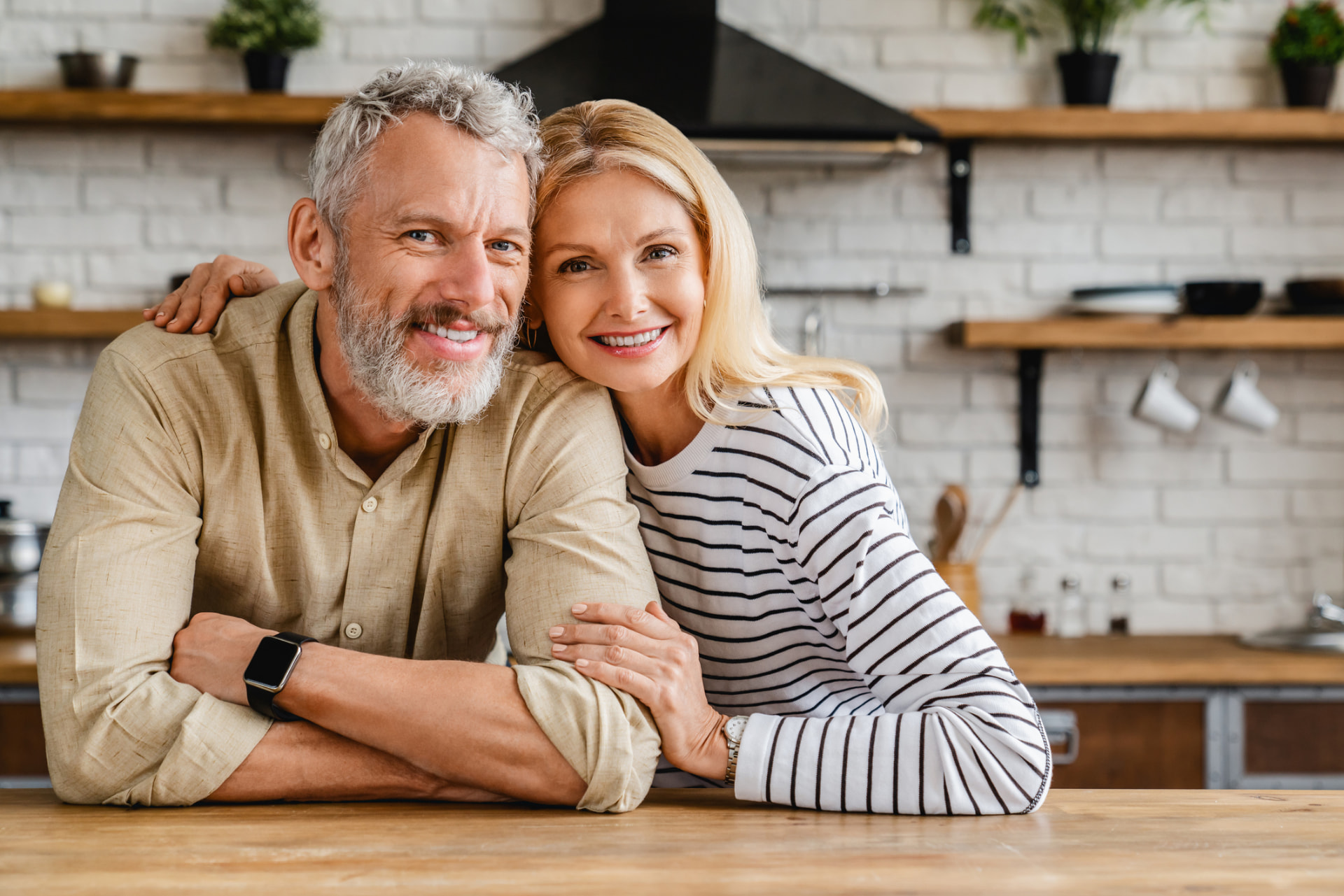 Couple de seniors souriant dans sa cuisine